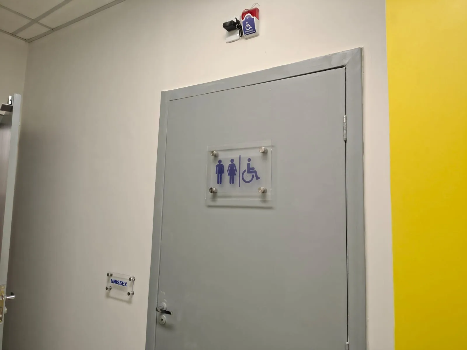 Porta de banheiro acessível com sinalização PCD