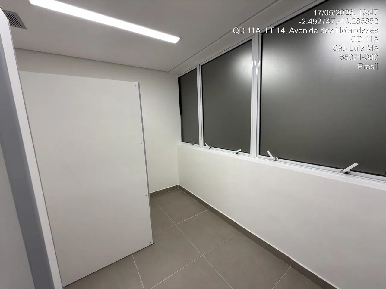Sala de atendimento com mesas brancas e divisórias de vidro