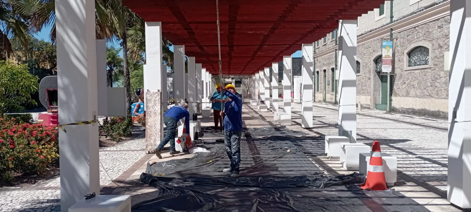 Equipe POLC trabalhando sob marquise vermelha em obra externa