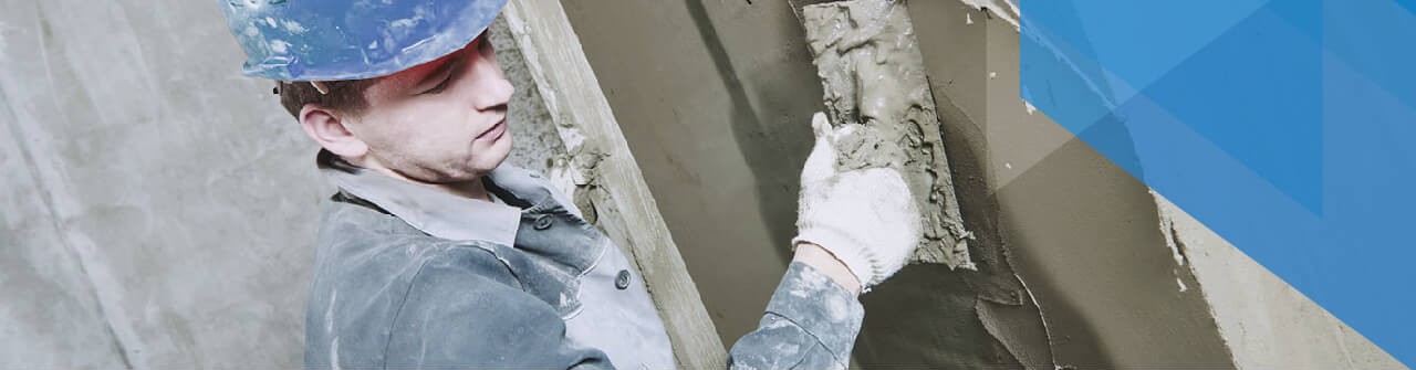 Profissional POLC com capacete realizando reboco em obra de alto padrão